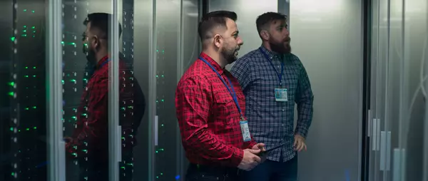 Zwei Männer im Rechenzentrum schauen sich Server-Racks an